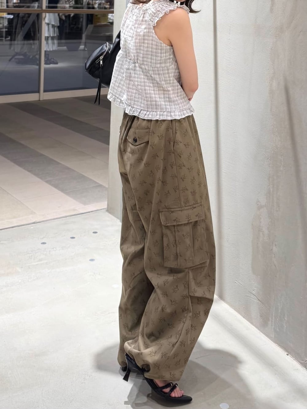 ブラウン系のデニムパンツ、ブラック系のサンダル、ブラック系のショルダーバッグを着用したレディースの夏コーディネートの2枚目の写真