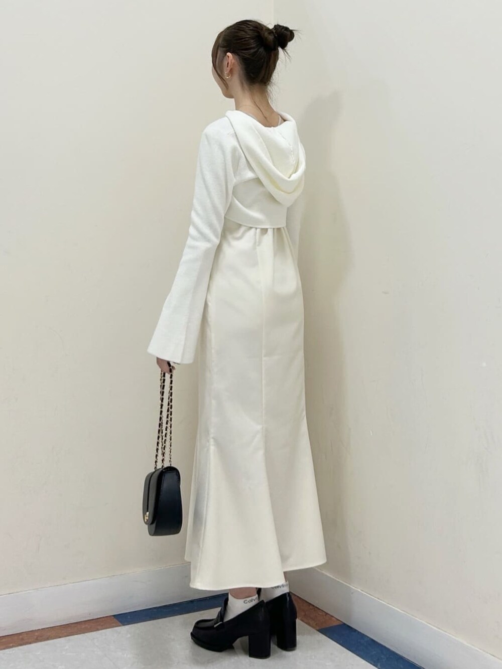 ホワイト系のワンピース、グレー系のローファー、ブラック系のショルダーバッグを着用したレディースの冬コーディネートの2枚目の写真