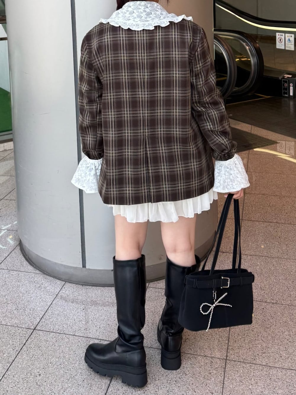 ブラウン系のテーラードジャケット、ホワイト系のスカート、ブラック系のショルダーバッグを着用したレディースの秋コーディネートの2枚目の写真