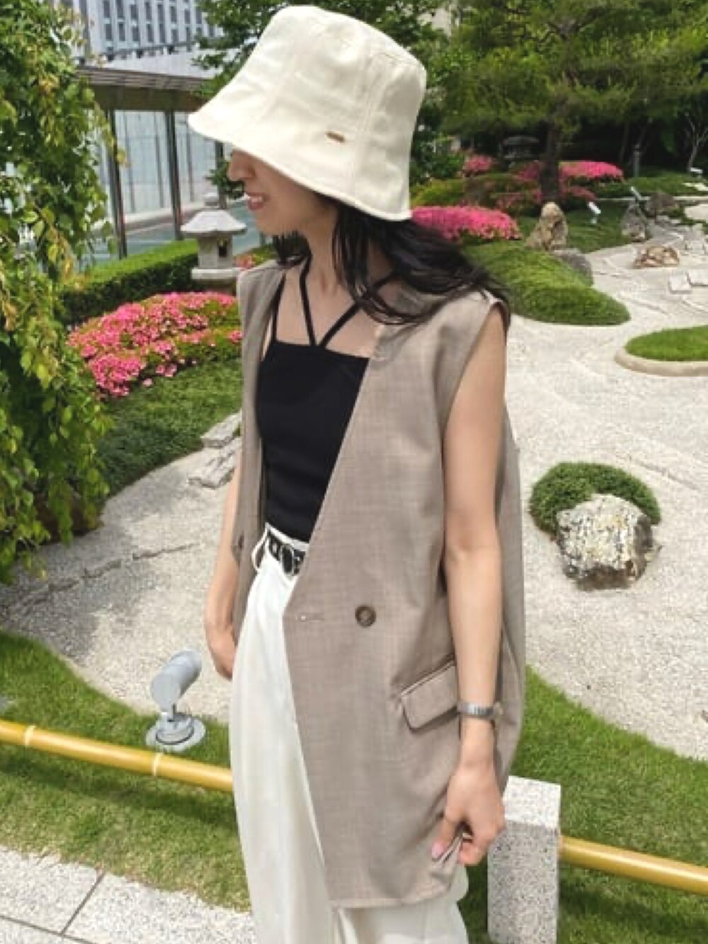 ブラウン系のその他アウター、ブラック系のキャミソール、ホワイト系のハットを着用したレディースの春コーディネートの3枚目の写真