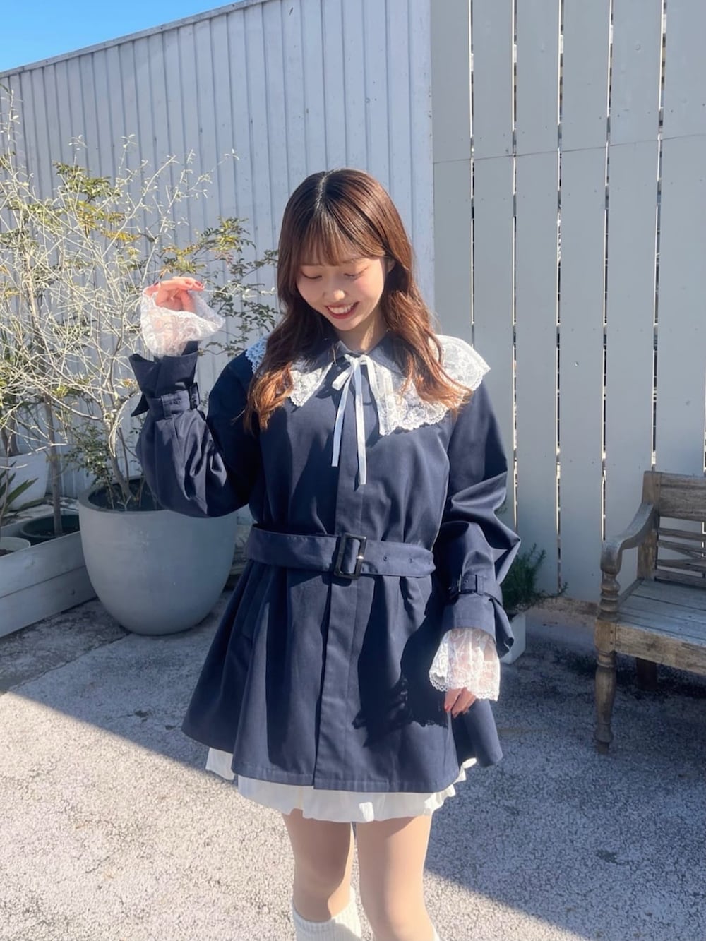 ブルー系のトレンチコート、イエロー系のカーディガン/ボレロを着用したレディースの冬コーディネートの4枚目の写真