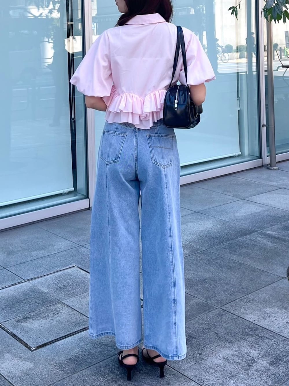 ブルー系のデニムパンツ、ピンク系のシャツ/ブラウス、ブラック系のボストンバッグを着用したレディースの夏コーディネートの3枚目の写真