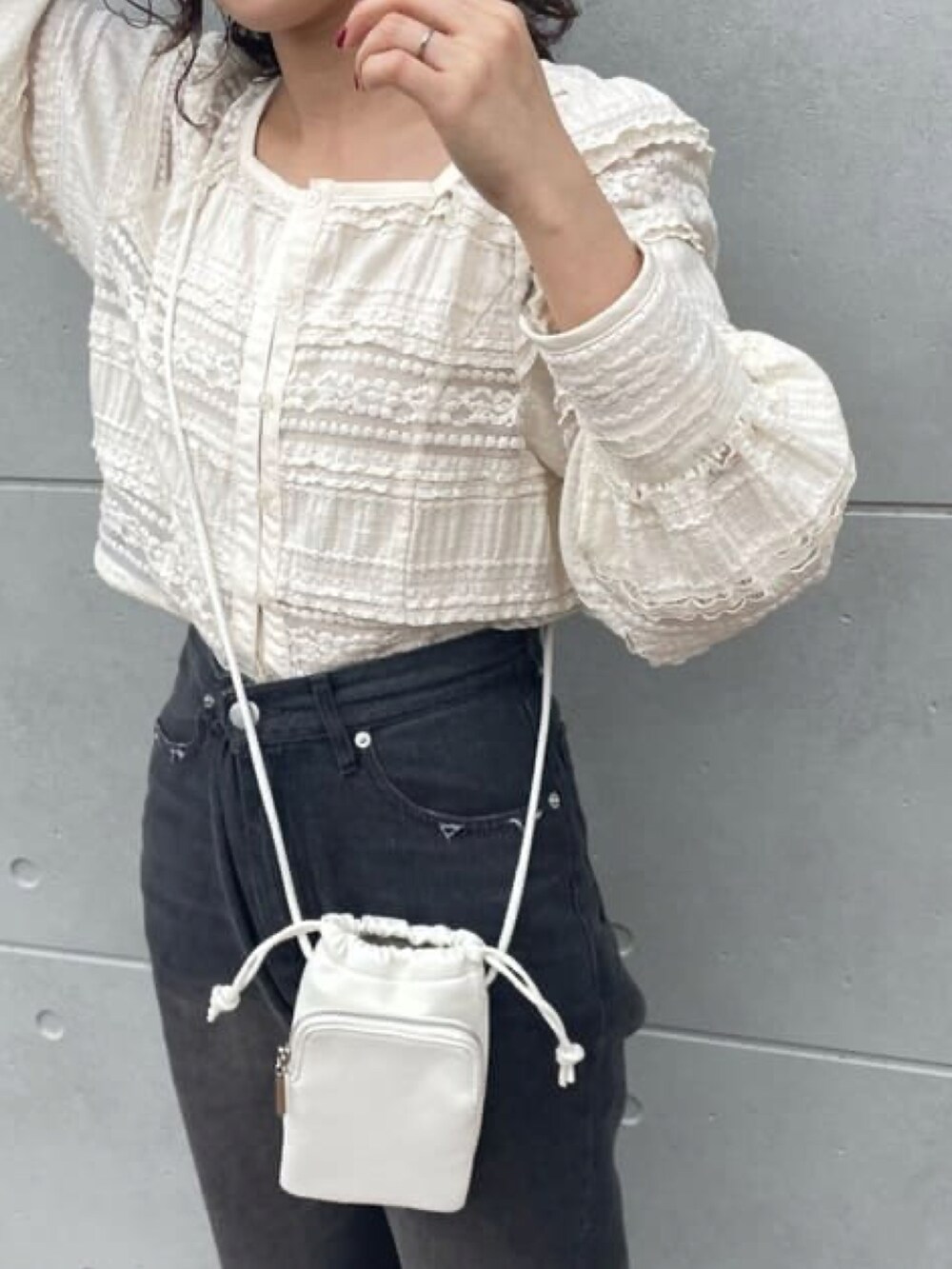 ホワイト系のシャツ/ブラウス、ブラック系のデニムパンツを着用したレディースの春コーディネートの2枚目の写真