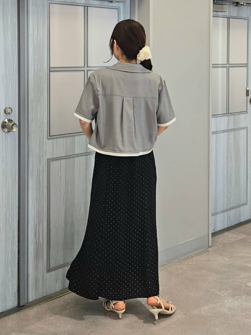 ブラック系のワンピース、グレー系のシャツ/ブラウス、ホワイト系のサンダルを着用したレディースの夏コーディネートの3枚目の写真
