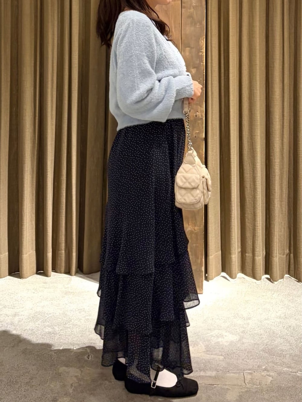 ブルー系のニット/セーター、ホワイト系のスカートを着用したレディースの秋コーディネートの2枚目の写真