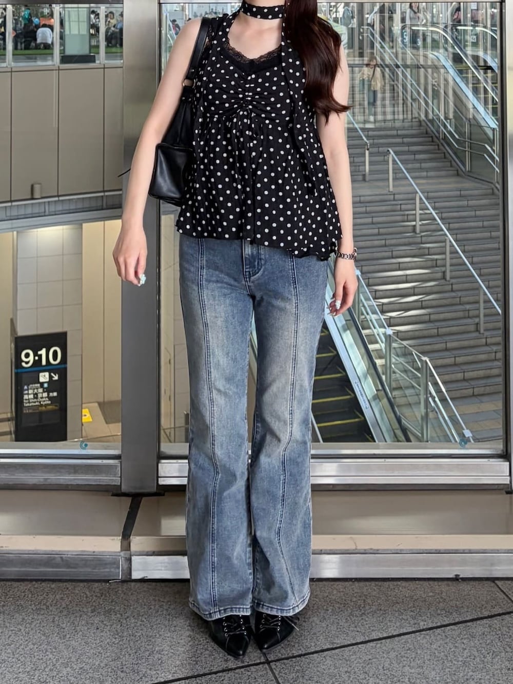 ブラック系のシャツ/ブラウス、ブルー系のデニムパンツを着用したレディースの春コーディネートの2枚目の写真