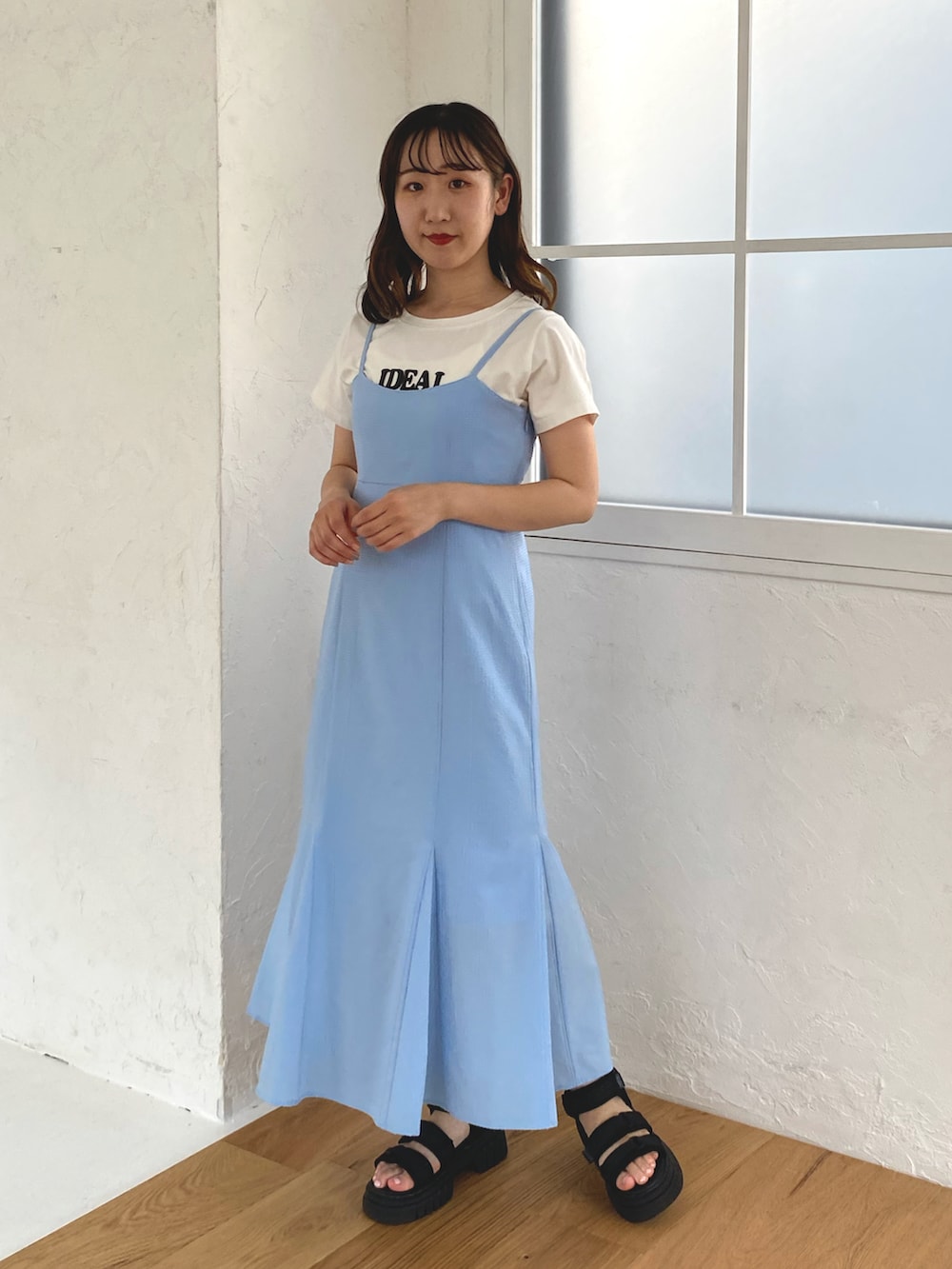 ブルー系のワンピース、ホワイト系のTシャツ/カットソー、ブラック系のサンダルを着用したレディースの春コーディネートの3枚目の写真