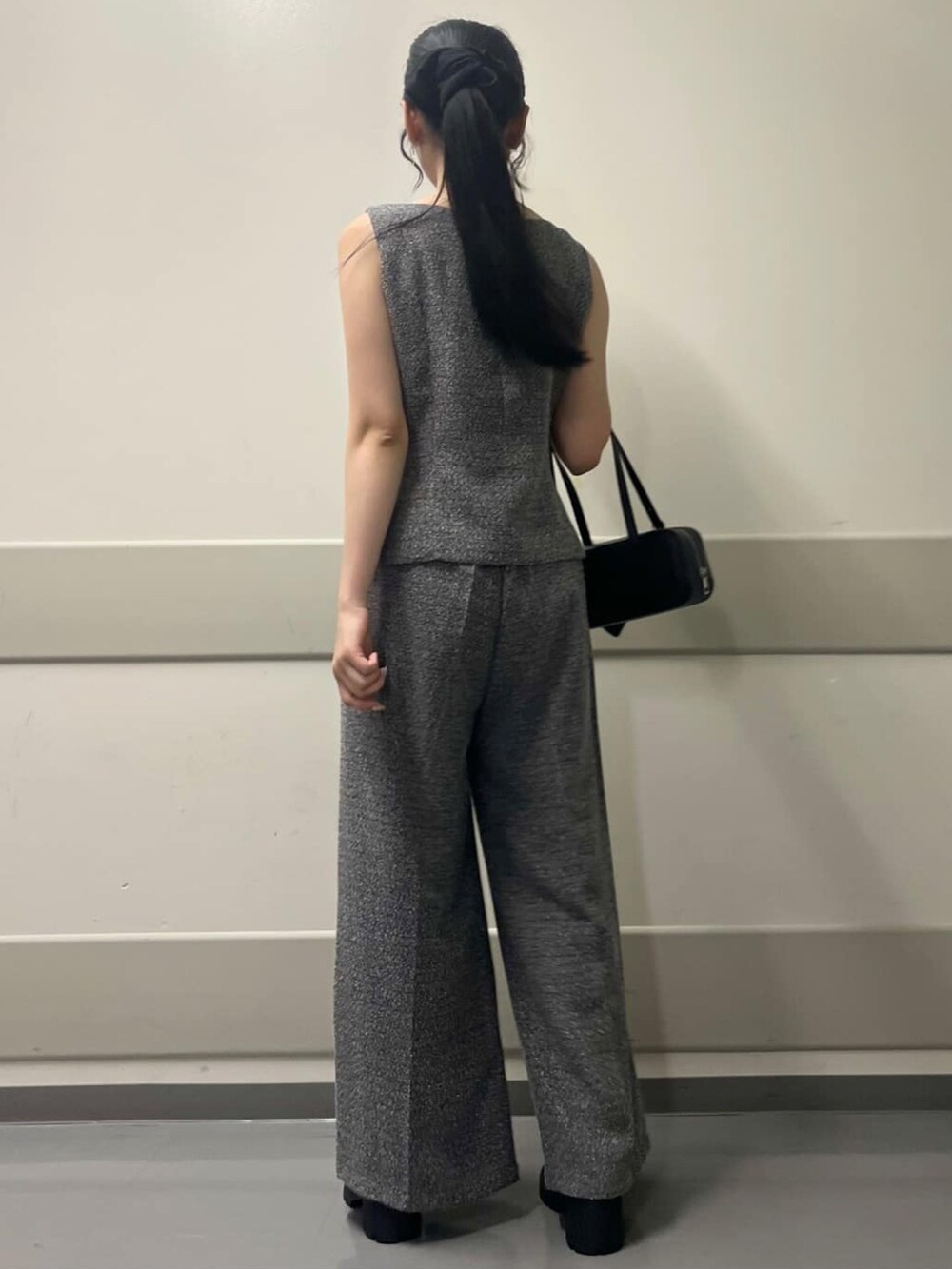 ブラック系のベスト、ブラック系のボストンバッグ、ブラック系のパンプスを着用したレディースの夏コーディネートの3枚目の写真