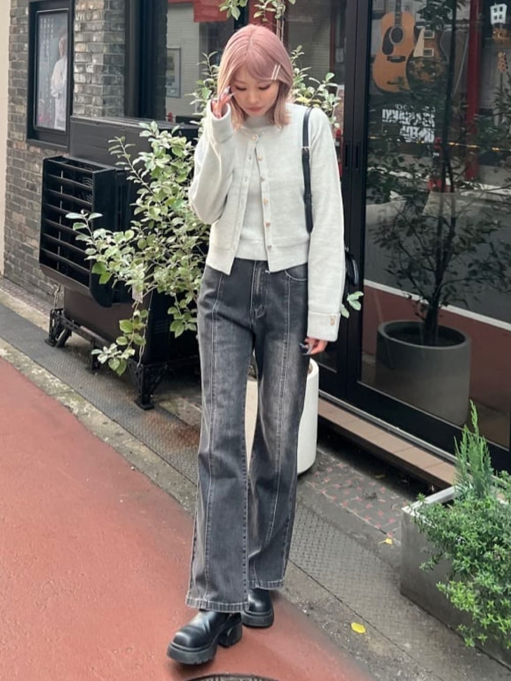 グリーン系のアンサンブル、グレー系のデニムパンツを着用したレディースの冬コーディネートの2枚目の写真