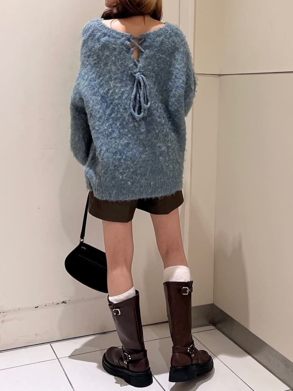レッド系のニット/セーター、ブラック系のその他パンツ、ブラウン系のブーツを着用したレディースの冬コーディネートの3枚目の写真