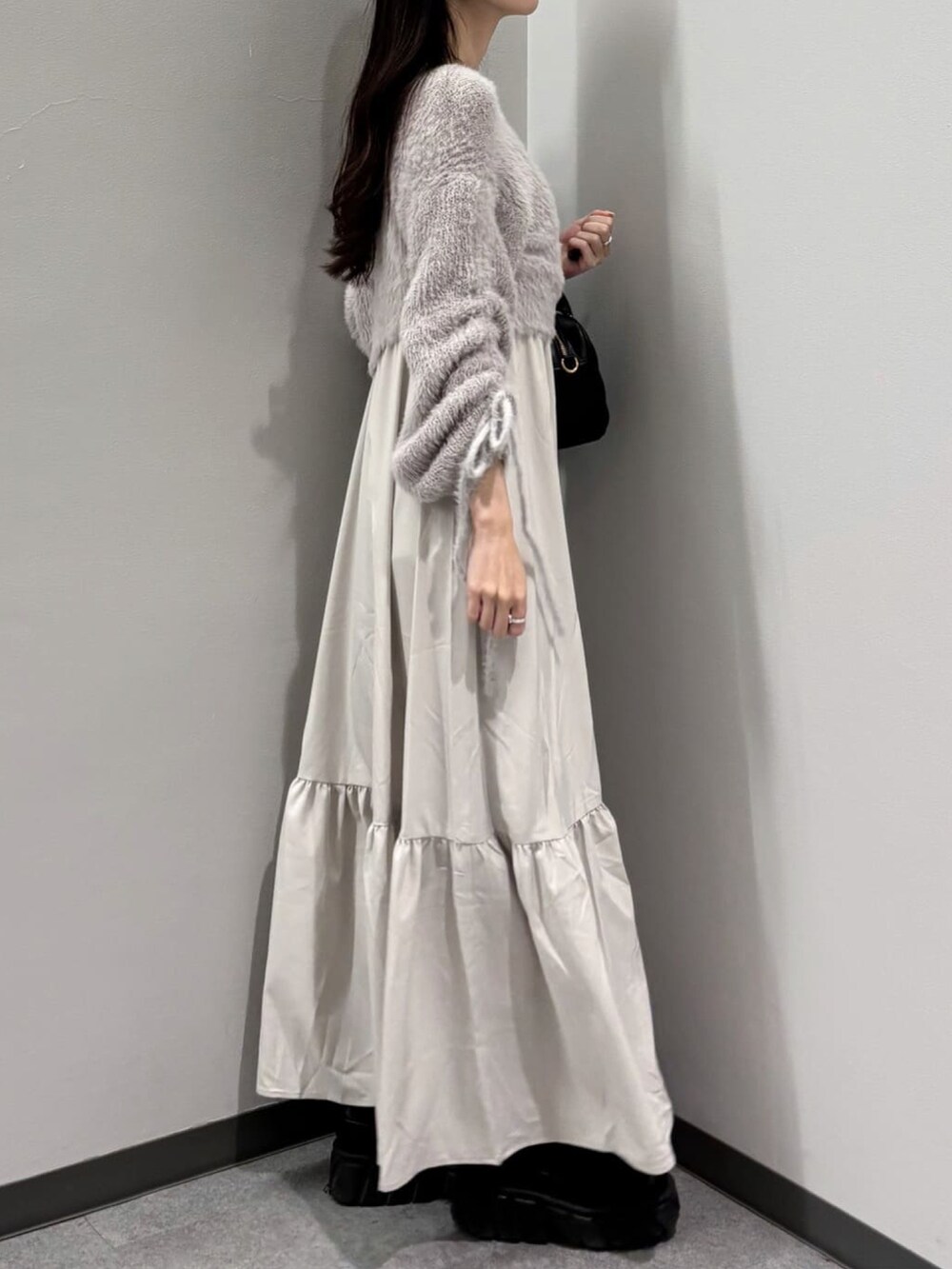 ベージュ系のワンピース、ブラック系のボストンバッグを着用したレディースの冬コーディネートの2枚目の写真