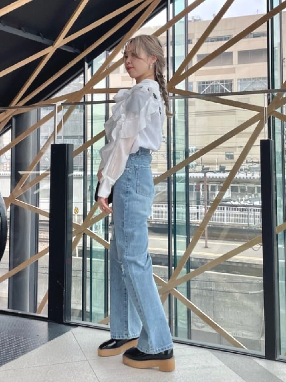 ブラック系のショルダーバッグ、ホワイト系のシャツ/ブラウス、ブルー系のデニムパンツを着用したレディースの冬コーディネートの3枚目の写真