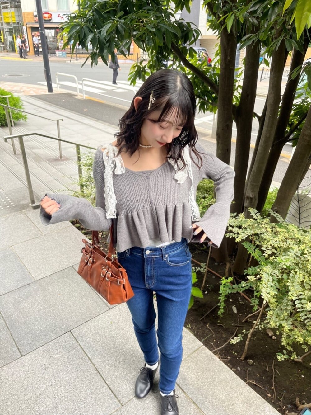 グレー系のアンサンブル、ブルー系のデニムパンツを着用したレディースの秋コーディネートの4枚目の写真