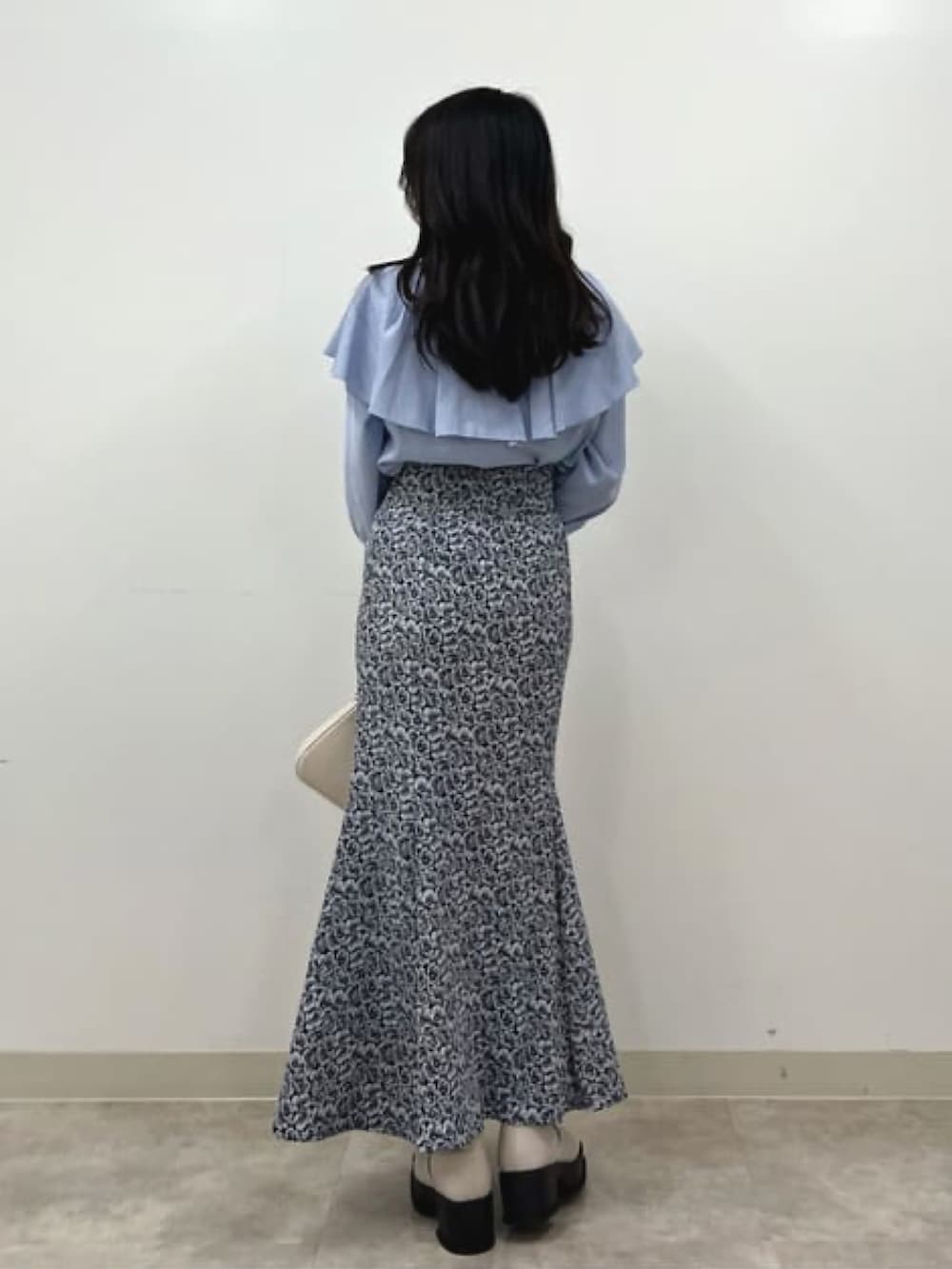 ホワイト系のブーツ、グレー系のスカート、ホワイト系のハンドバッグを着用したレディースの冬コーディネートの2枚目の写真