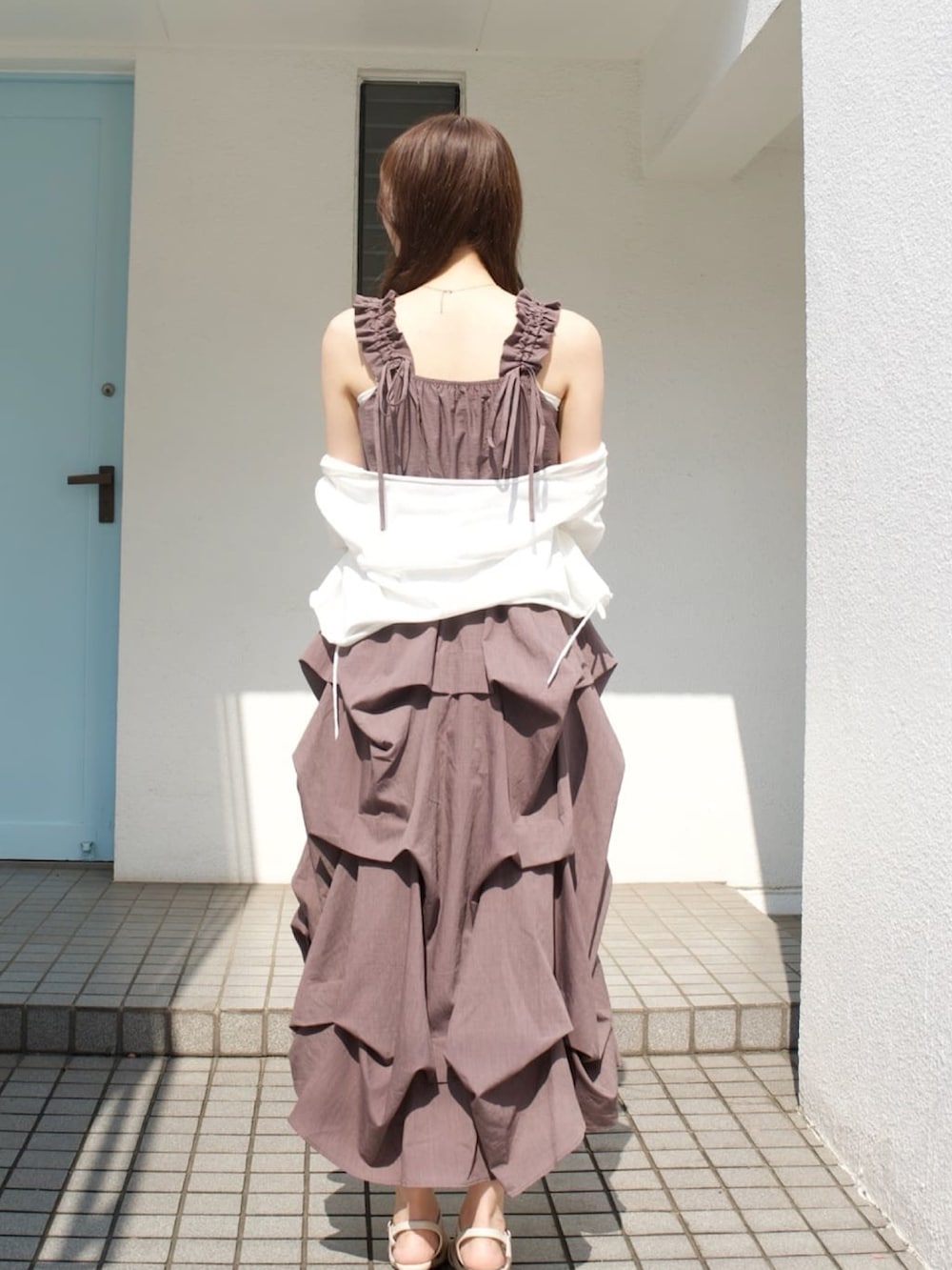 ブラウン系のワンピース、ホワイト系のニット/セーター、ホワイト系のサンダルを着用したレディースの夏コーディネートの3枚目の写真