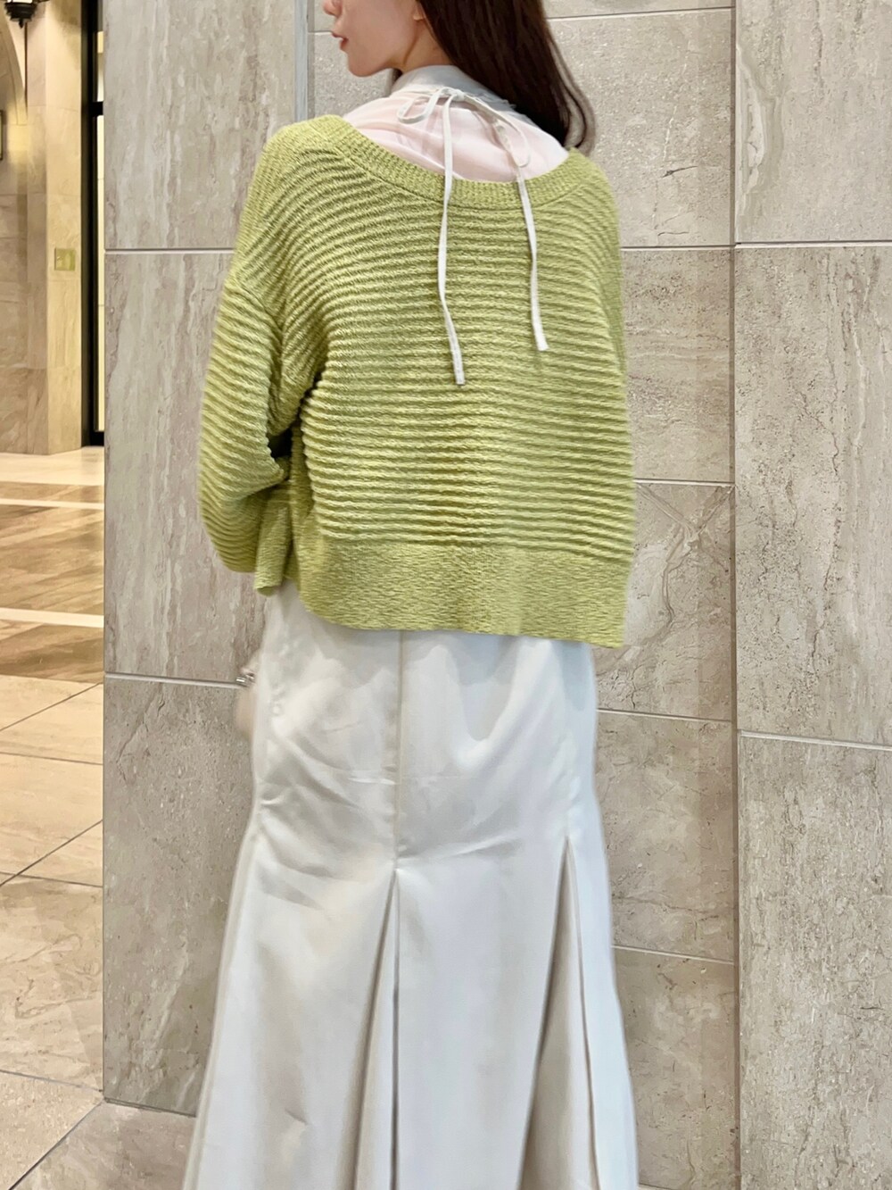 イエロー系のカーディガン/ボレロ、ホワイト系のワンピース、ホワイト系のTシャツ/カットソーを着用したレディースの冬コーディネートの3枚目の写真