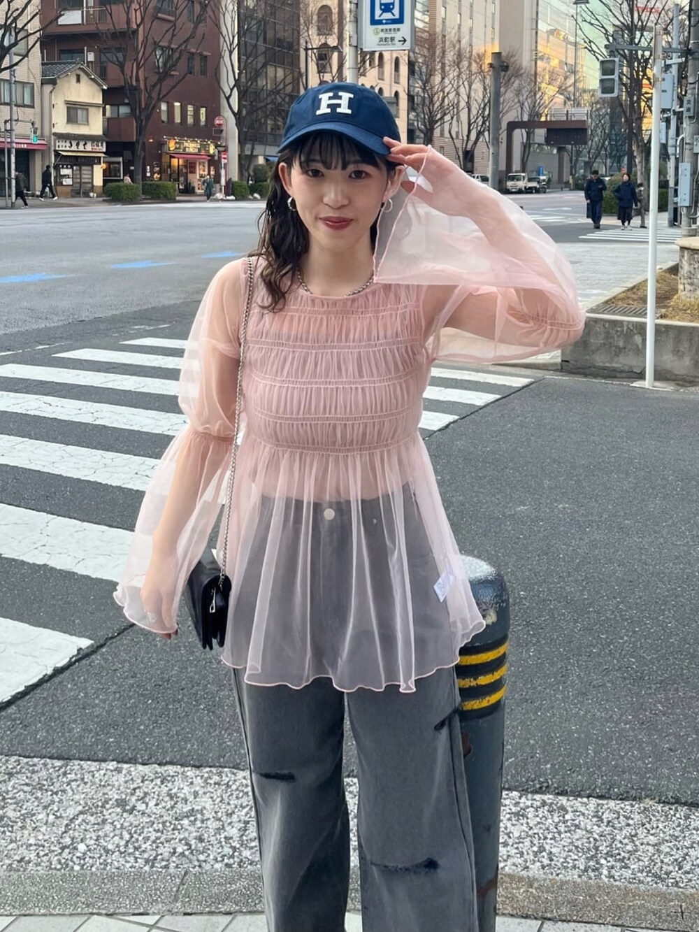 ピンク系のシャツ/ブラウス、ブルー系のデニムパンツを着用したレディースの春コーディネートの2枚目の写真