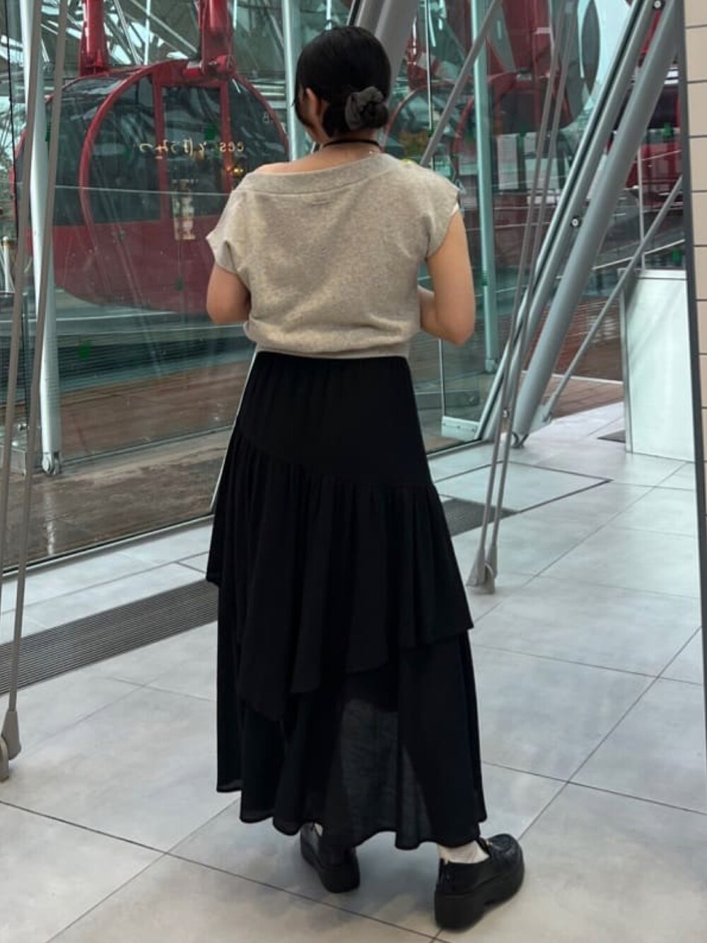 グレー系のスウェット、ブラック系のスカートを着用したレディースの夏コーディネートの3枚目の写真