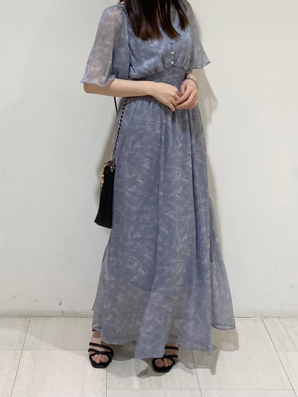 ホワイト系のワンピース、ブラック系のハンドバッグ、ホワイト系のサンダルを着用したレディースの夏コーディネートの2枚目の写真