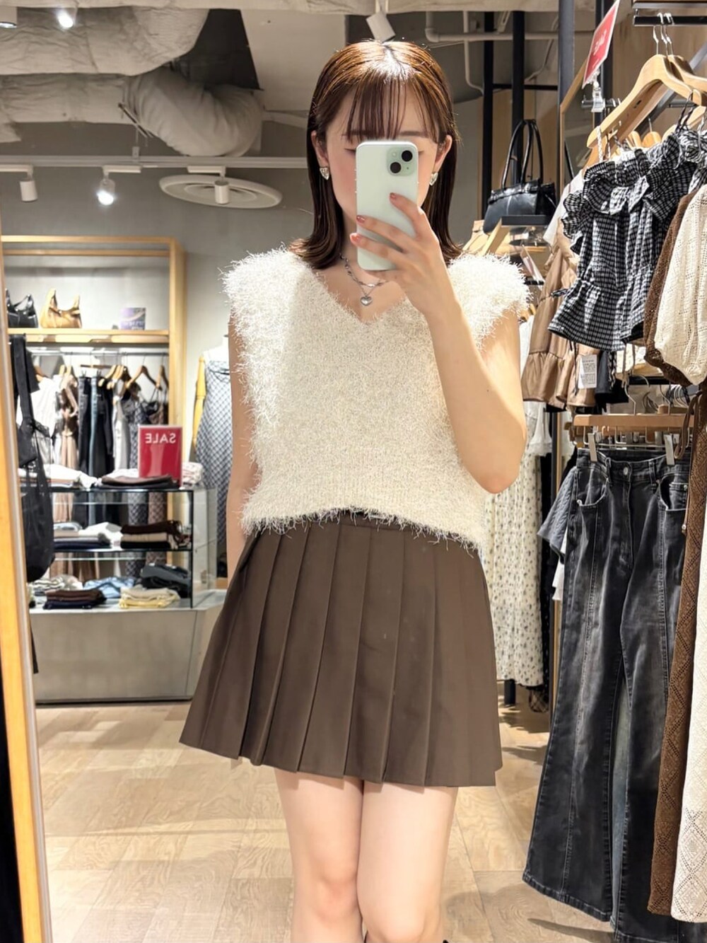 ブラウン系のスカート、ホワイト系のベストを着用したレディースの夏コーディネートの3枚目の写真