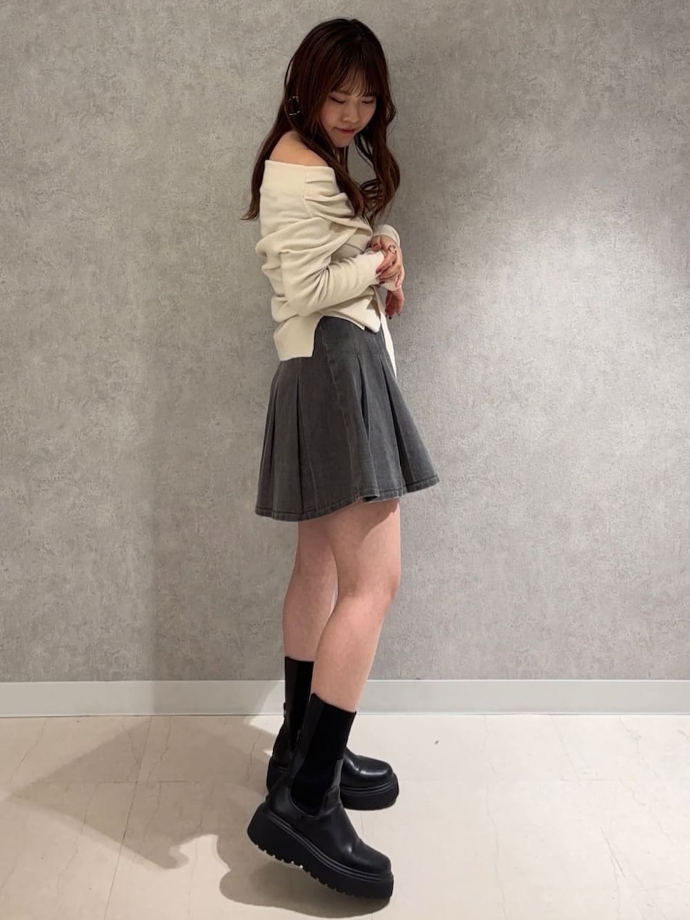 ホワイト系のニット/セーター、グレー系のスカートを着用したレディースの冬コーディネートの2枚目の写真