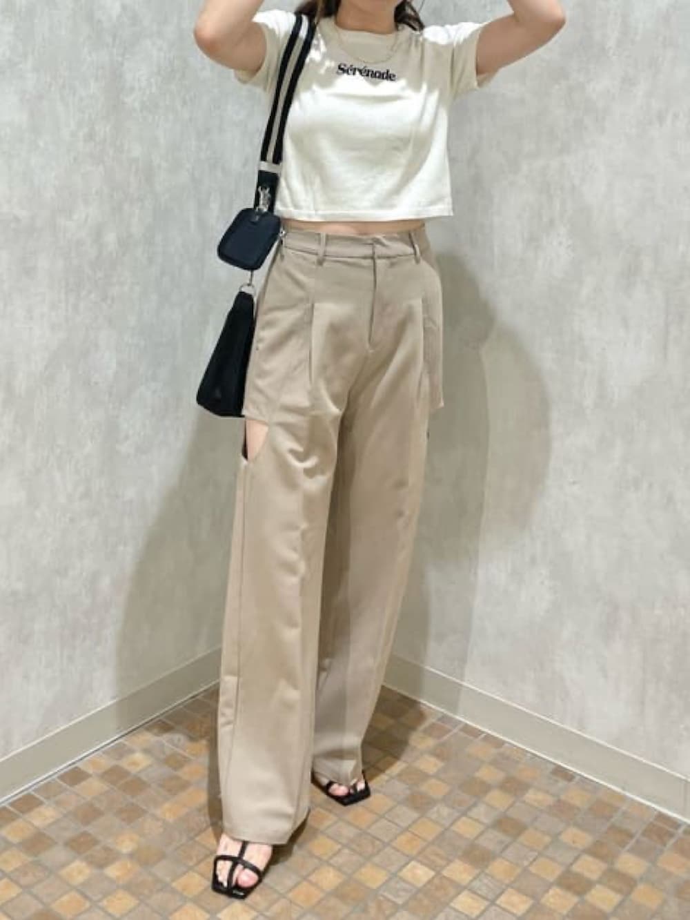 ホワイト系のニット/セーター、ベージュ系のその他パンツ、ブラック系のショルダーバッグを着用したレディースの夏コーディネートの3枚目の写真