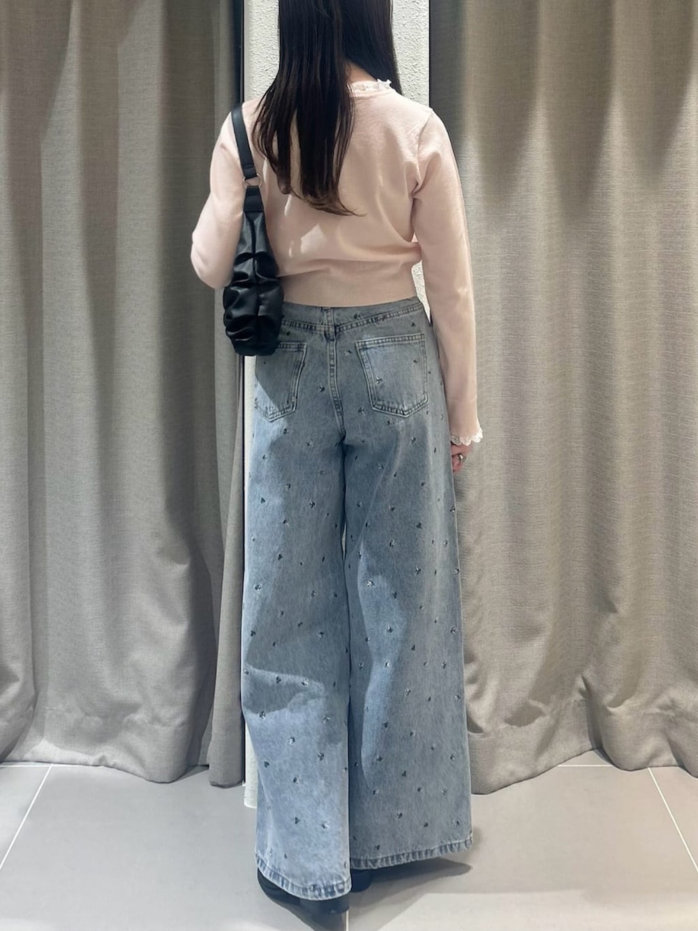 ピンク系のニット/セーター、ブルー系のデニムパンツを着用したレディースの春コーディネートの3枚目の写真