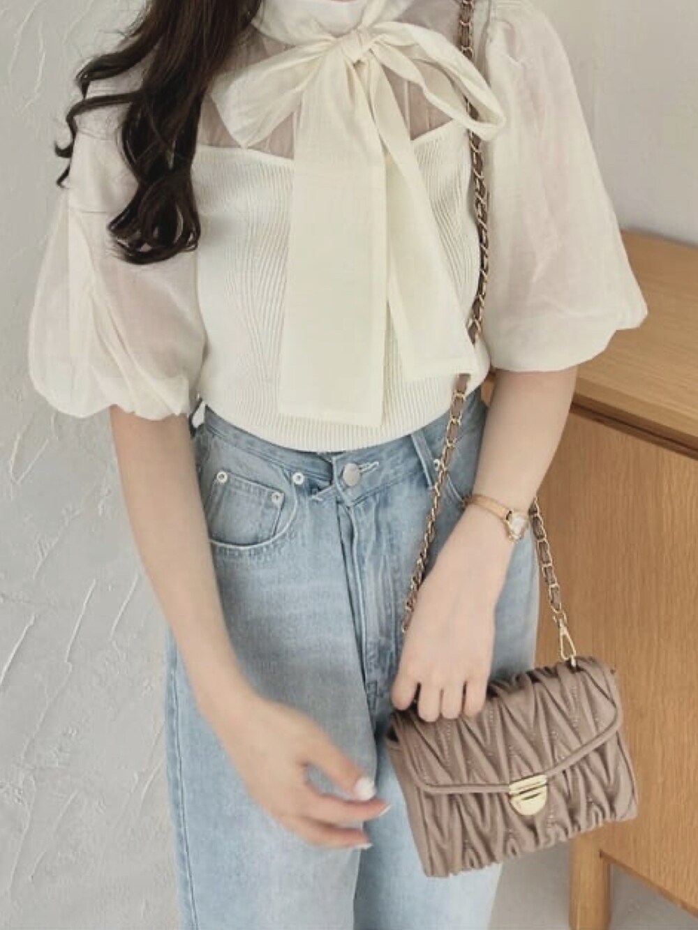 ブルー系のデニムパンツ、ホワイト系のサンダル、ブラウン系のショルダーバッグを着用したレディースの夏コーディネートの3枚目の写真