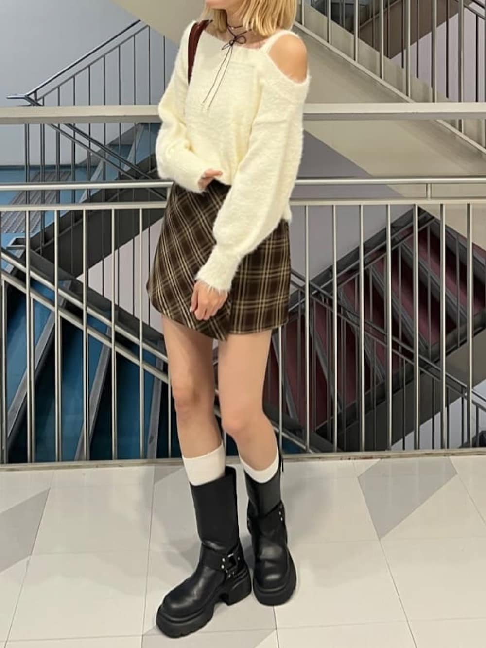 ホワイト系のニット/セーター、ブラウン系のスカート、レッド系のボストンバッグを着用したレディースの秋コーディネートの2枚目の写真