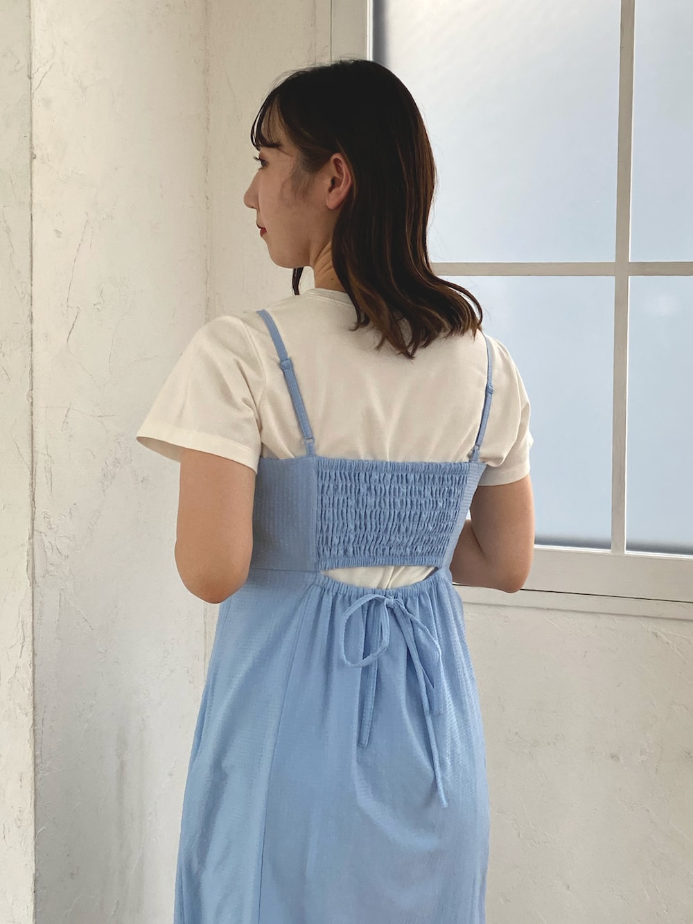 ブルー系のワンピース、ホワイト系のTシャツ/カットソー、ブラック系のサンダルを着用したレディースの春コーディネートの2枚目の写真