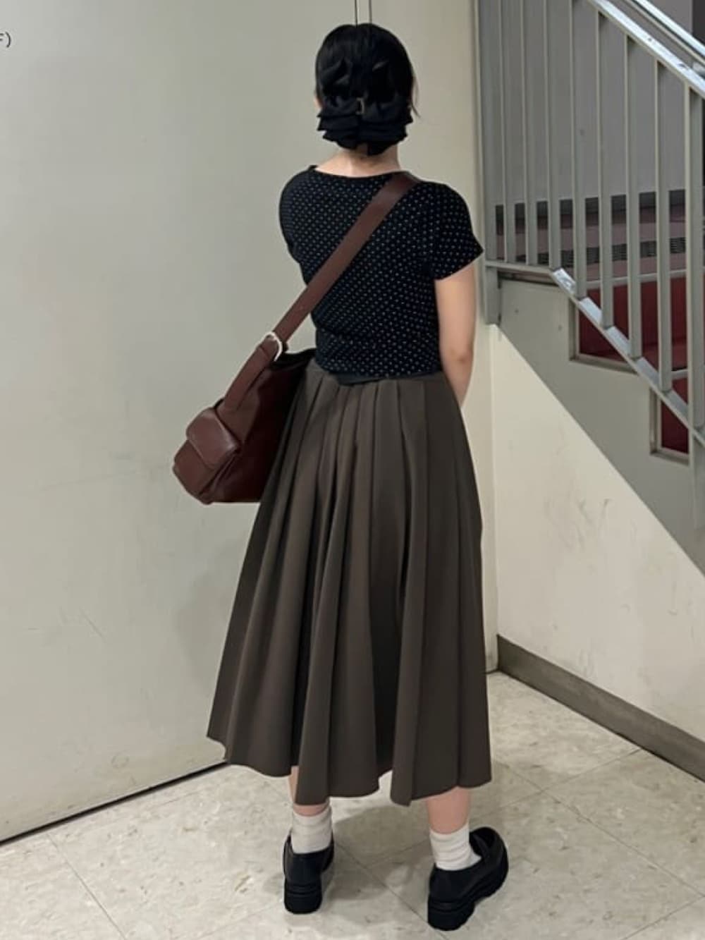 ブラウン系のスカート、ブラック系のショルダーバッグを着用したレディースの夏コーディネートの3枚目の写真