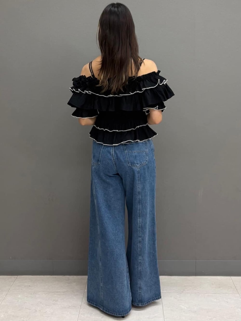 ブルー系のデニムパンツ、ブラック系のサンダル、ブラック系のシャツ/ブラウスを着用したレディースの夏コーディネートの3枚目の写真