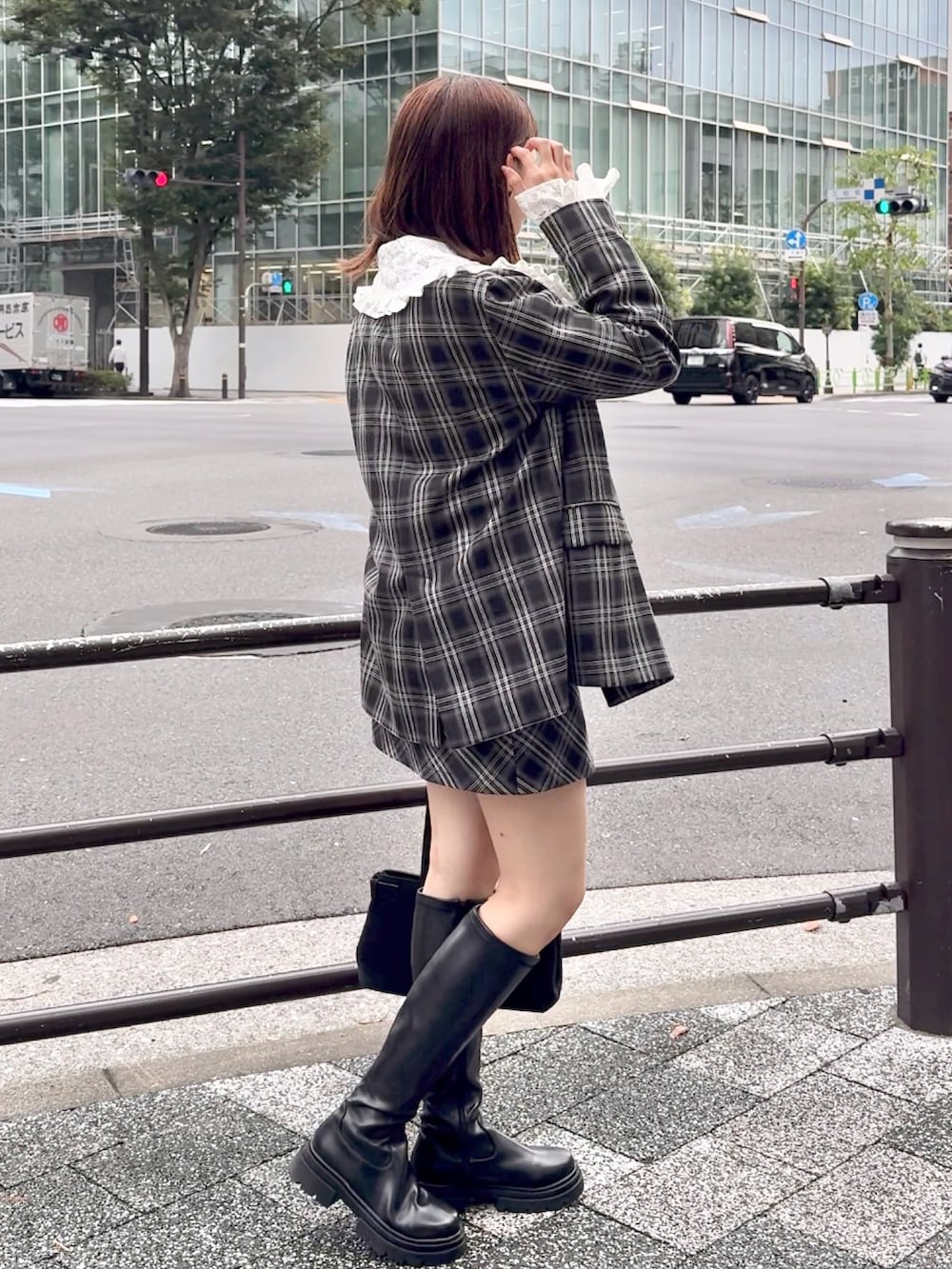 グレー系のテーラードジャケット、ブラック系のショルダーバッグを着用したレディースの秋コーディネートの2枚目の写真