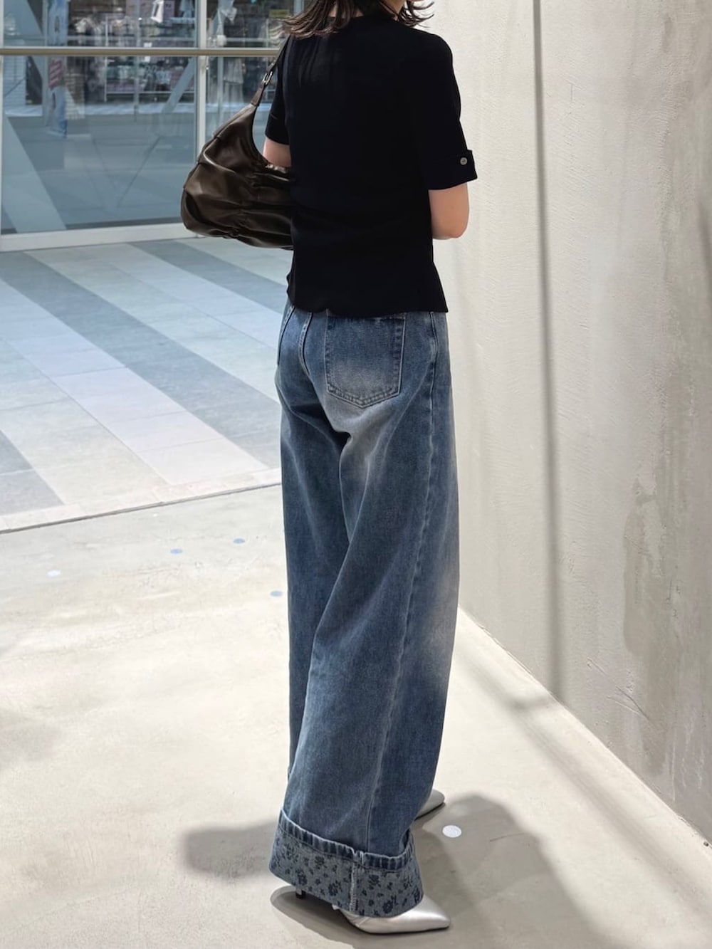 ブルー系のデニムパンツ、ブラック系のニット/セーター、グレー系のパンプスを着用したレディースの夏コーディネートの2枚目の写真