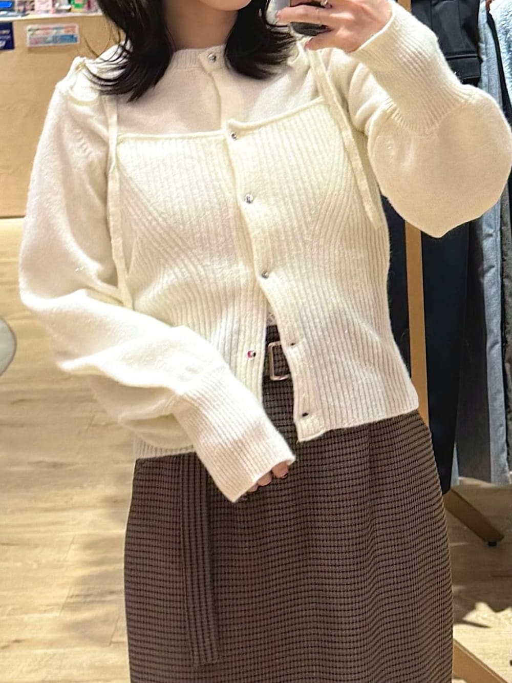 ホワイト系のニット/セーター、オレンジ系のスカート、ブラック系のローファーを着用したレディースの冬コーディネートの3枚目の写真