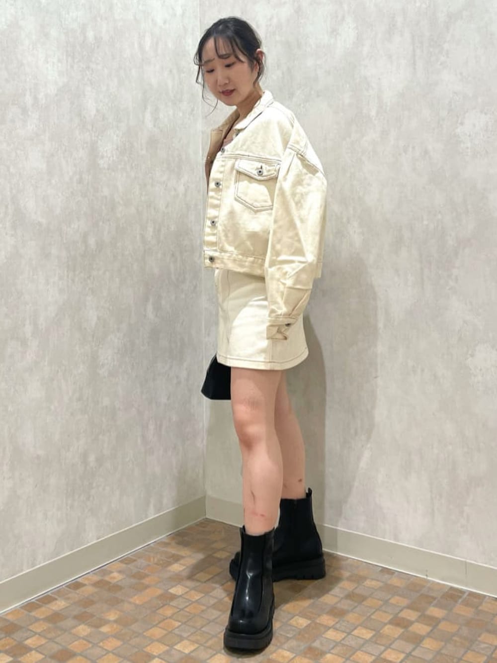 ホワイト系のデニムジャケット、ピンク系のTシャツ/カットソー、ホワイト系のデニムスカートを着用したレディースの春コーディネートの2枚目の写真