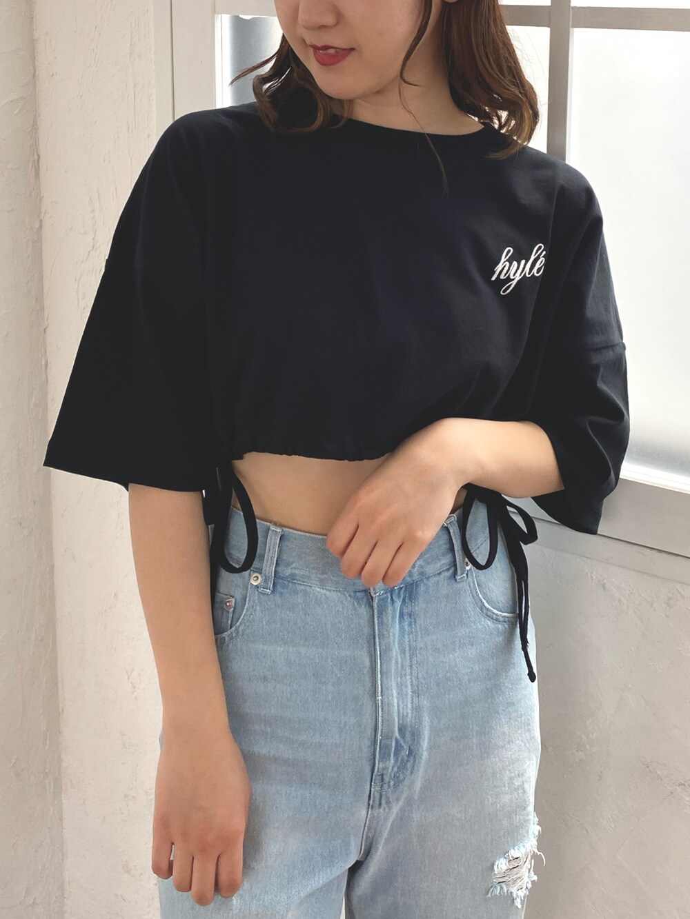 ブラック系のTシャツ/カットソー、ブルー系のデニムパンツ、ホワイト系のサンダルを着用したレディースの春コーディネートの3枚目の写真