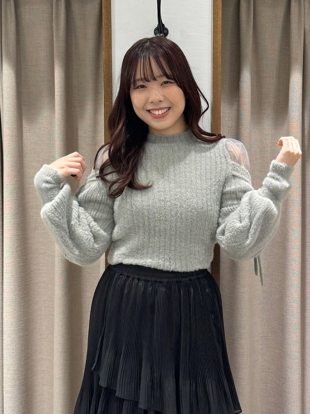 グレー系のニット/セーター、ブラック系のスカート、ブラック系のブーツを着用したレディースの冬コーディネートの3枚目の写真