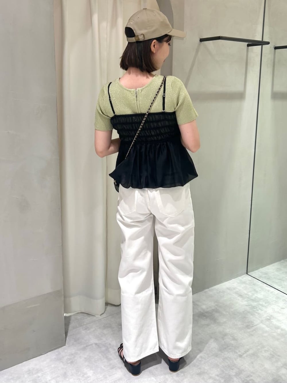 ホワイト系のシャツ/ブラウス、イエロー系のニット/セーター、ホワイト系のデニムパンツを着用したレディースの夏コーディネートの2枚目の写真