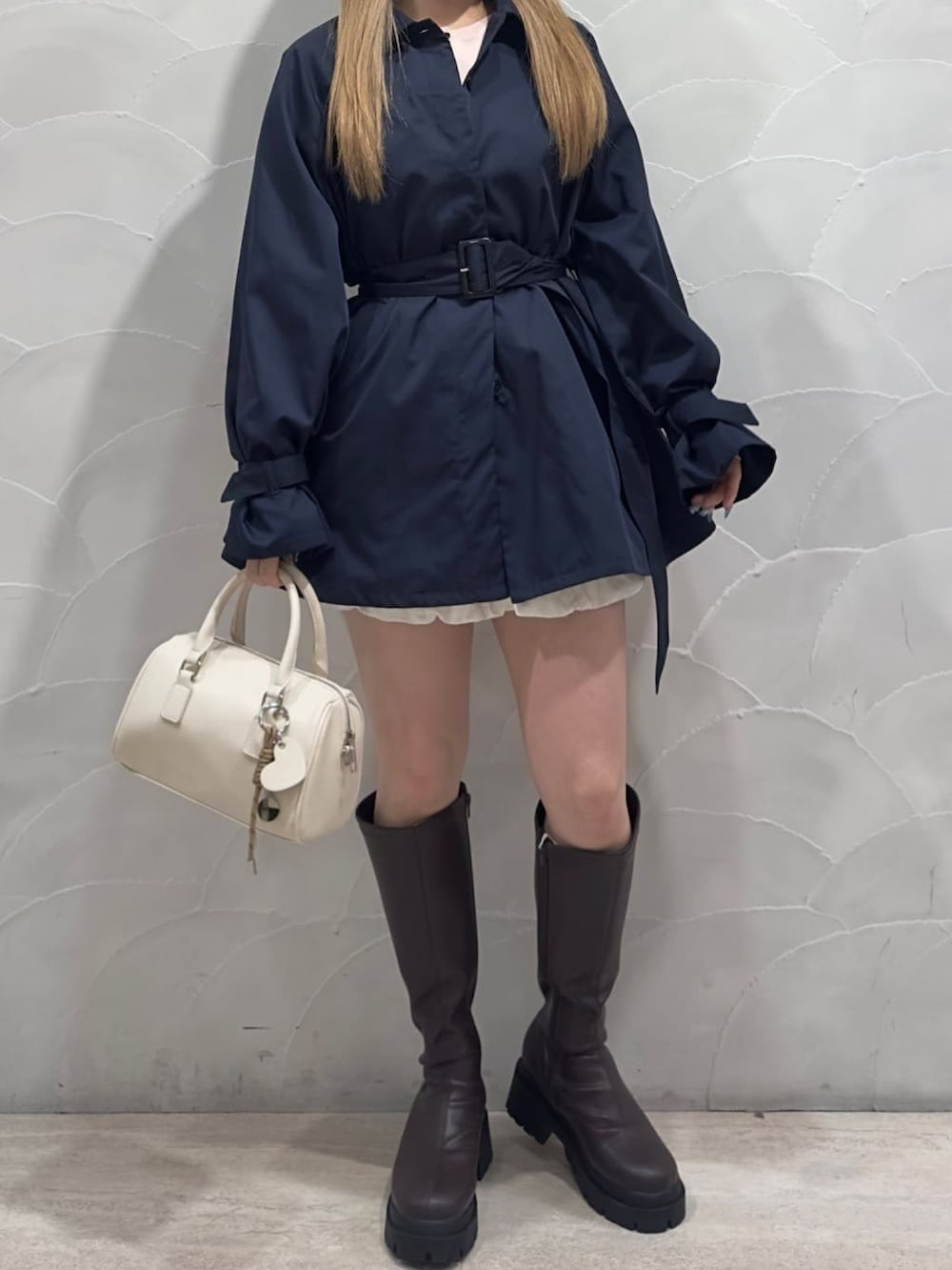 ブルー系のトレンチコート、ピンク系のカーディガン/ボレロを着用したレディースの冬コーディネートの3枚目の写真