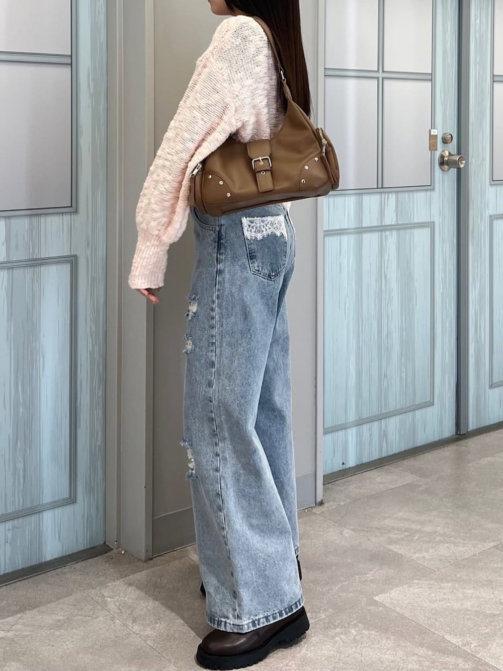 ピンク系のカーディガン/ボレロ、ブルー系のデニムパンツを着用したレディースの冬コーディネートの2枚目の写真