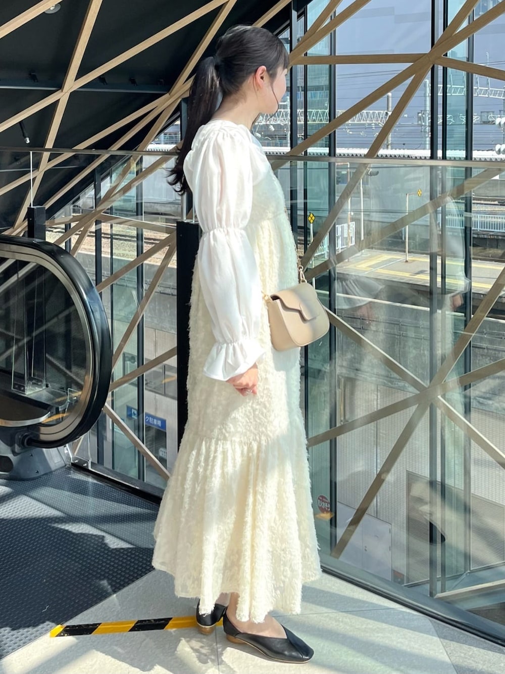 ホワイト系のシャツ/ブラウス、ホワイト系のワンピース、ブラック系のパンプスを着用したレディースの春コーディネートの2枚目の写真