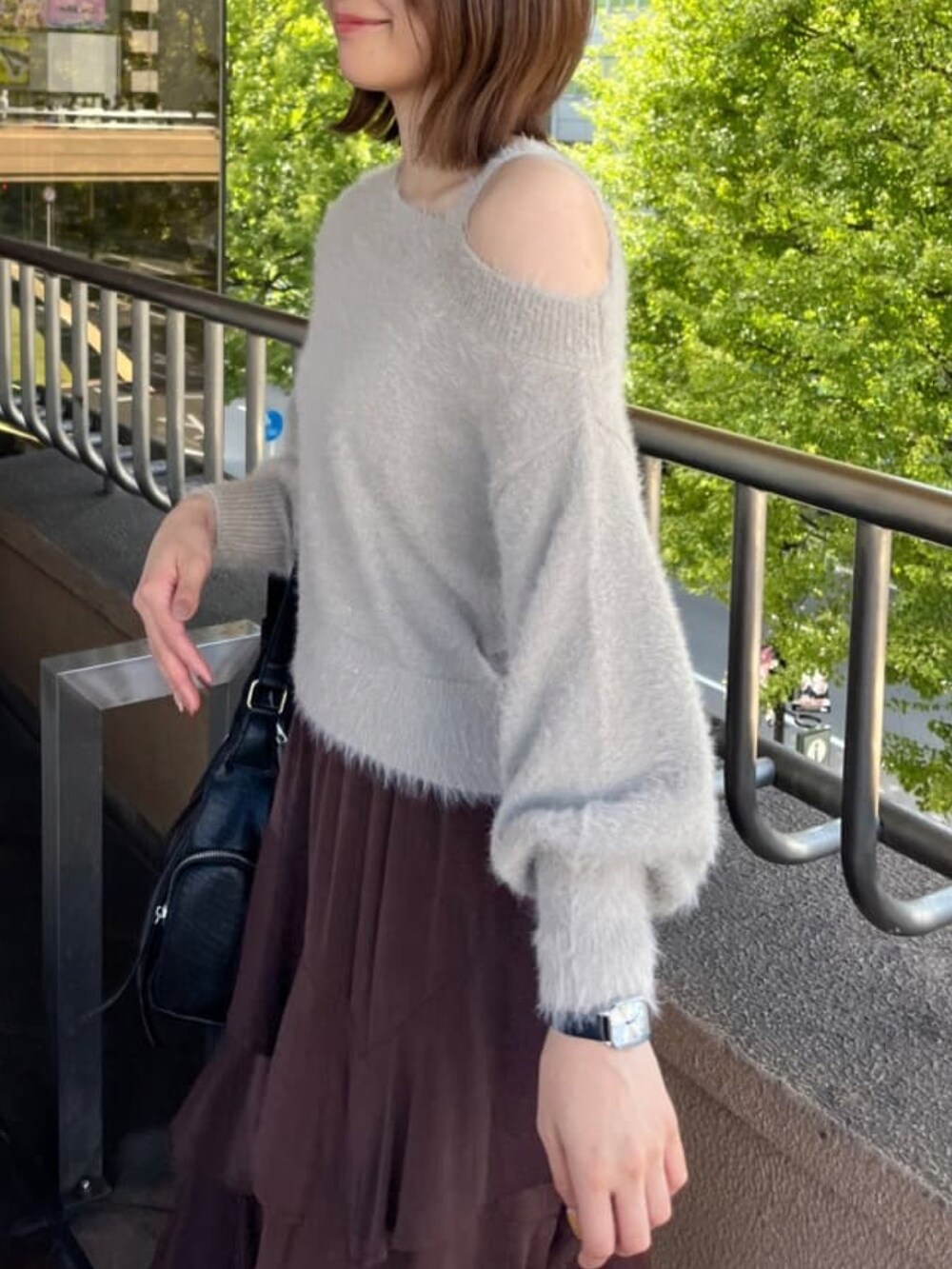 ベージュ系のニット/セーター、ブラウン系のスカート、ブラック系のハンドバッグを着用したレディースの秋コーディネートの3枚目の写真