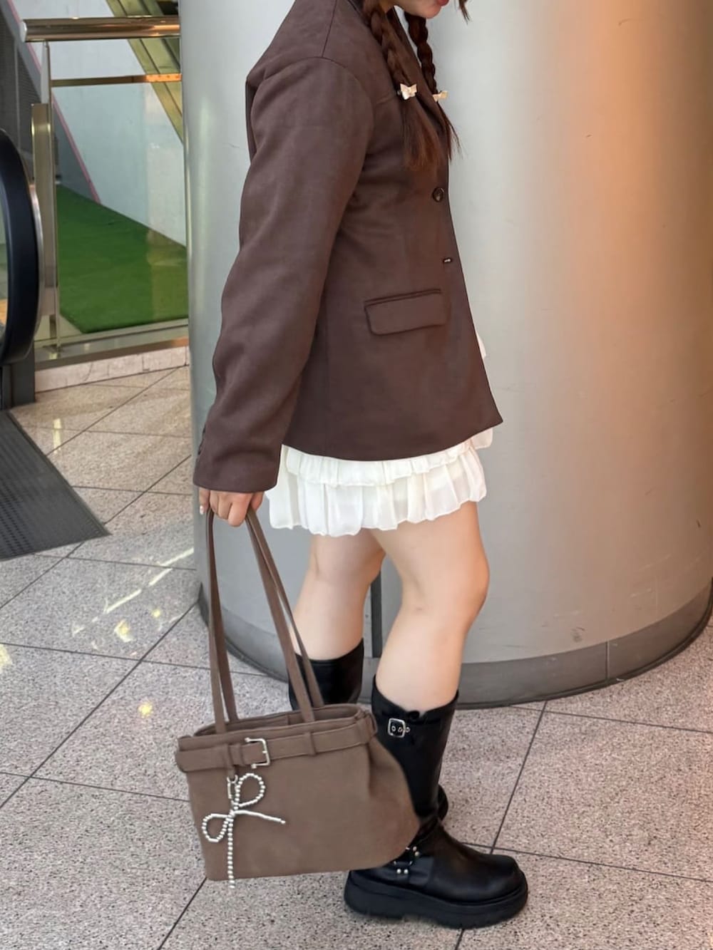 ブラウン系のテーラードジャケット、ブラウン系のショルダーバッグを着用したレディースの秋コーディネートの2枚目の写真