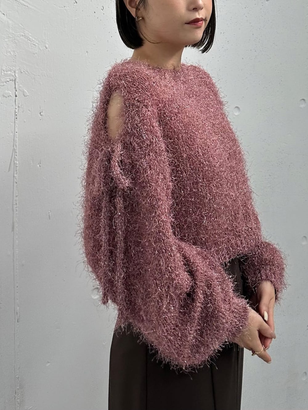 ピンク系のニット/セーター、ブラウン系のスカート、ブラウン系のブーツを着用したレディースの冬コーディネートの2枚目の写真