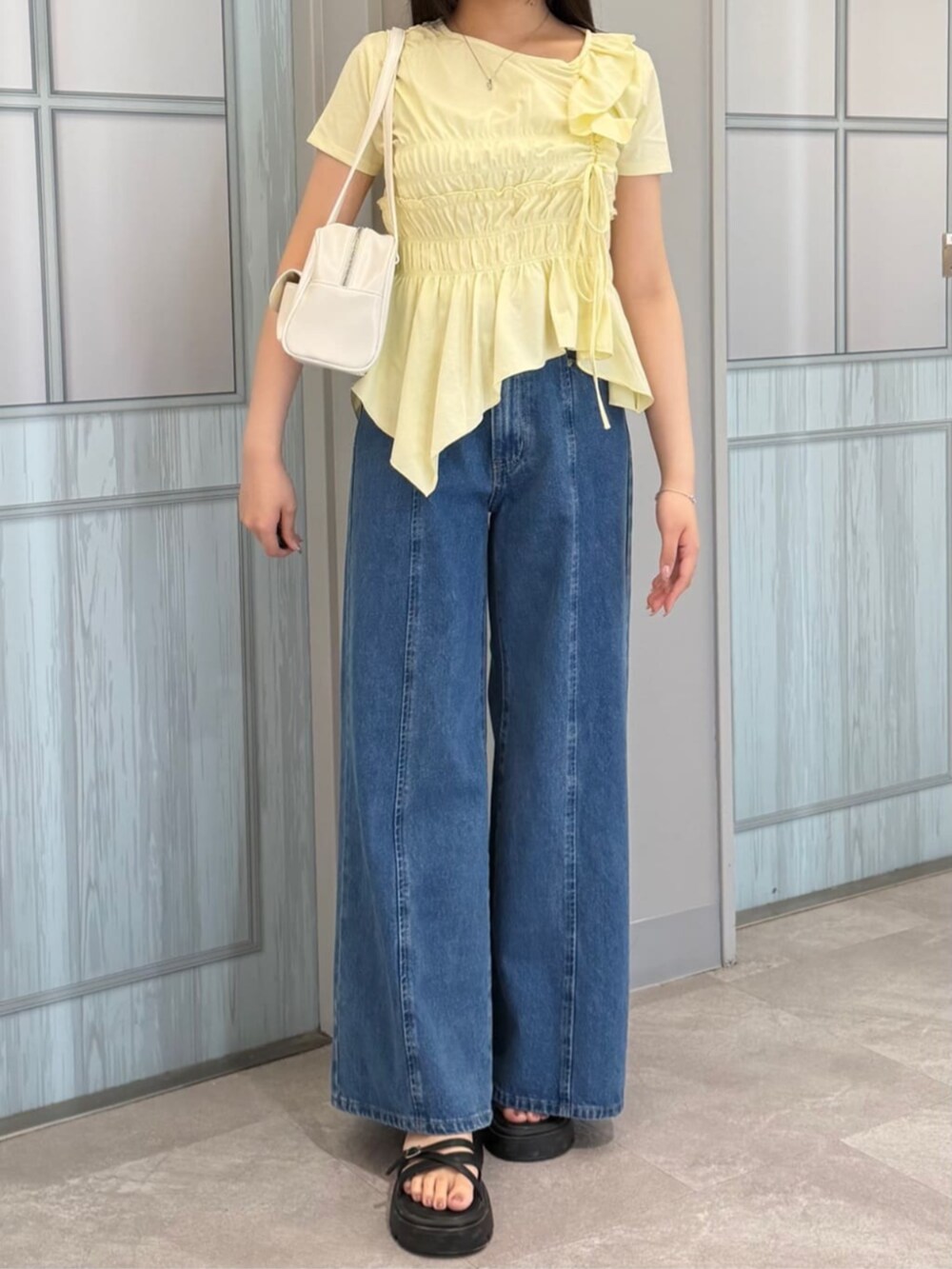 ブルー系のデニムパンツ、ベージュ系のTシャツ/カットソーを着用したレディースの夏コーディネートの2枚目の写真