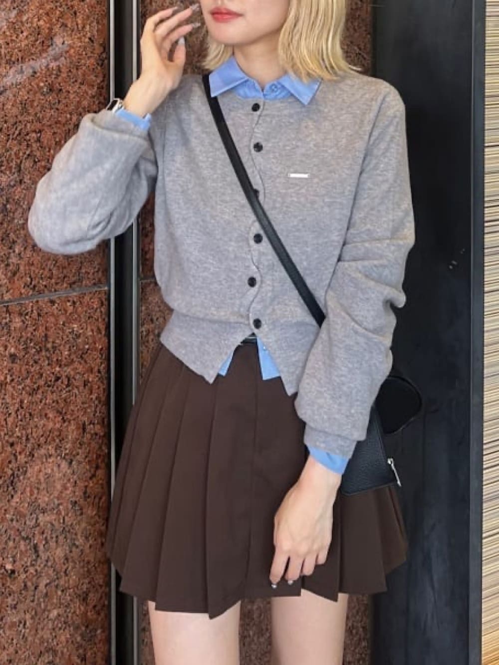 グレー系のカーディガン/ボレロ、ブラウン系のスカート、ブラウン系のブーツを着用したレディースの秋コーディネートの3枚目の写真