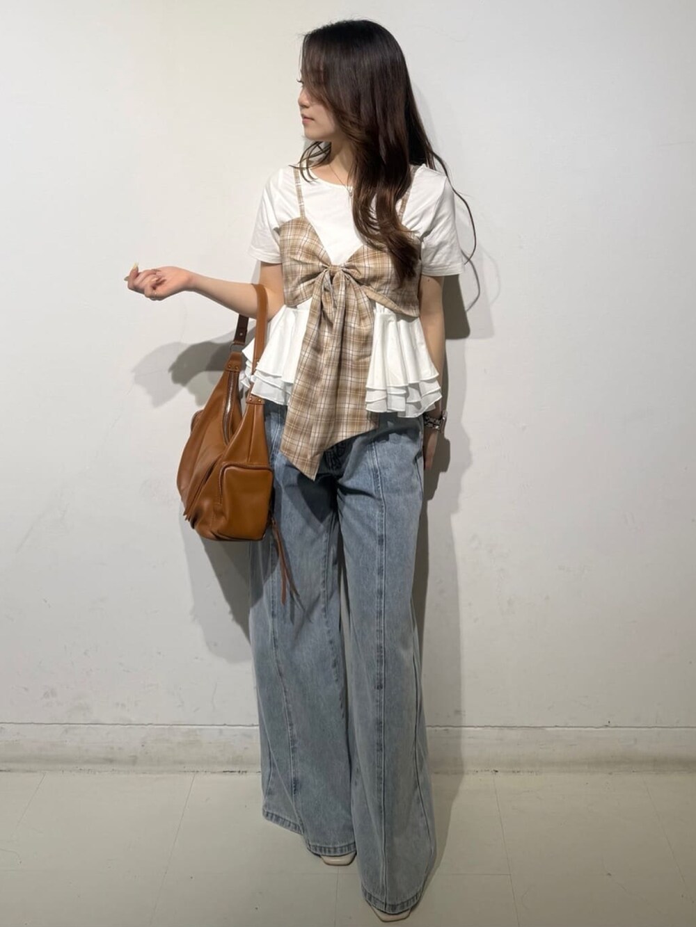 ベージュ系のTシャツ/カットソー、ブルー系のデニムパンツを着用したレディースの夏コーディネートの2枚目の写真
