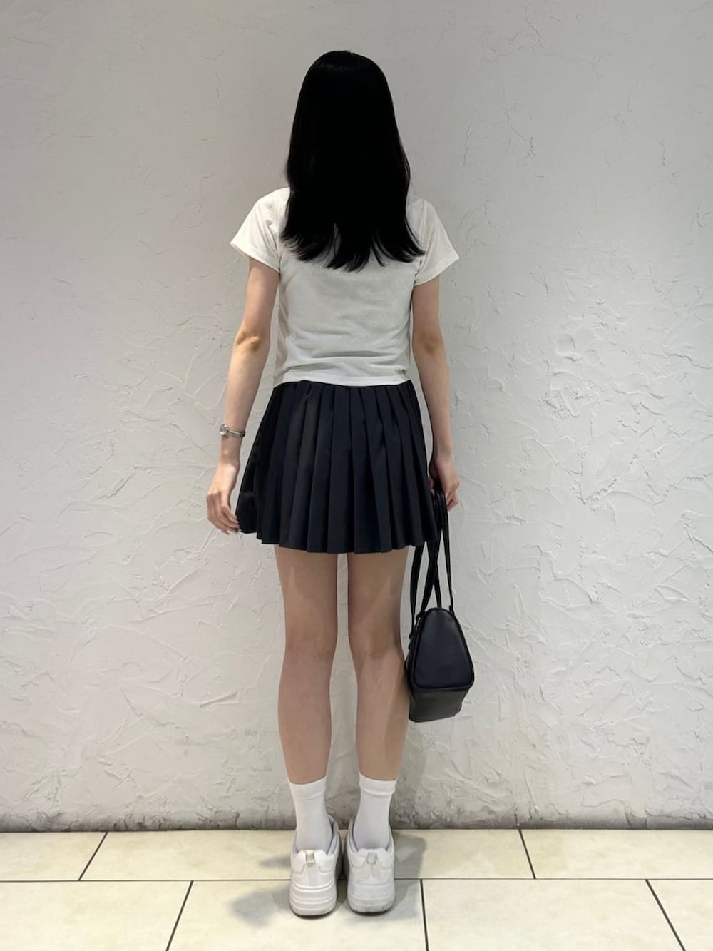 グレー系のスカート、ホワイト系のアンサンブルを着用したレディースの夏コーディネートの3枚目の写真