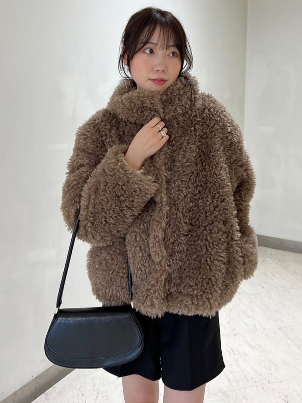 ホワイト系のニット/セーター、ブラウン系のその他アウター、ブラック系のその他パンツを着用したレディースの冬コーディネートの3枚目の写真